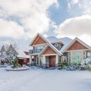 A view of a suburban home covered in snow during the winter months.